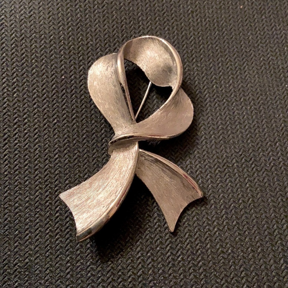 Jonette Jewelry Logo Vintage Silver Tone Ribbon Brooch Elegant Sculptural Pin.